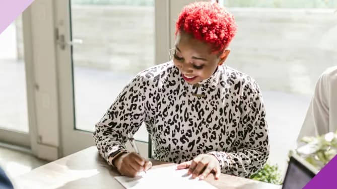 A woman signing a contract, illustrating how to achieve financial goals