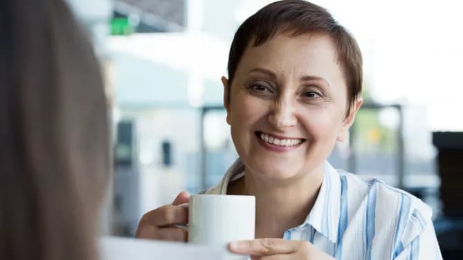 Woman smiling holding coffee cup