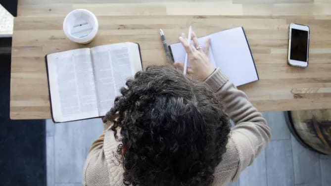 woman reading the bible and taking notes