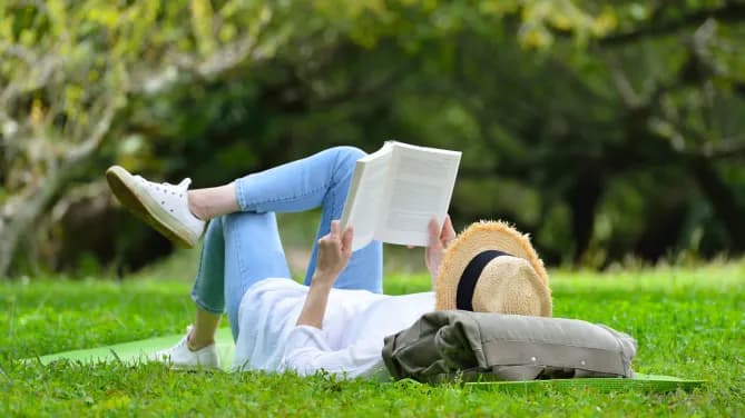 woman playing hooky from work reading in the park