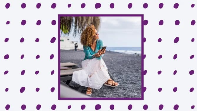 a woman sitting on her phone on the beach. 