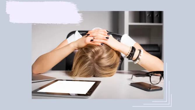 a woman with her head down at her desk