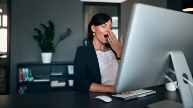 Woman yawning at computer