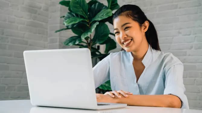 Woman smiling at laptop.