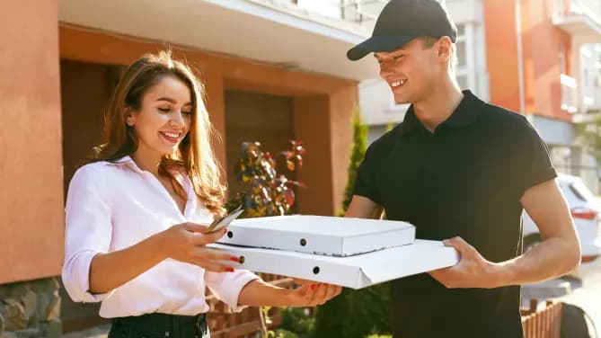Woman getting pizza from a deliveryman 