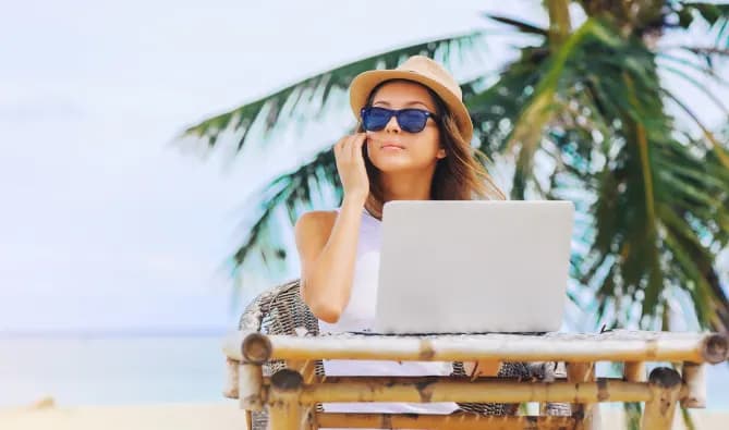 Woman working on laptop at beach