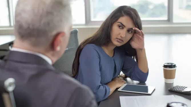 Woman annoyed with boss at work