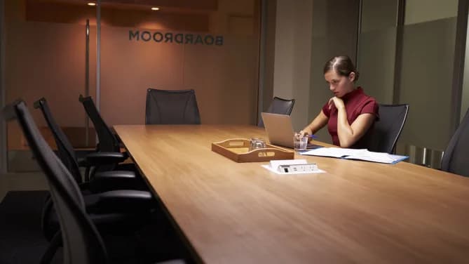 Woman sitting alone at a conference table