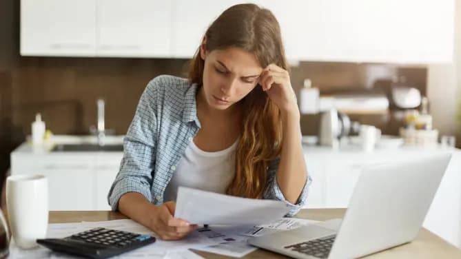 woman looking through finances and laptop