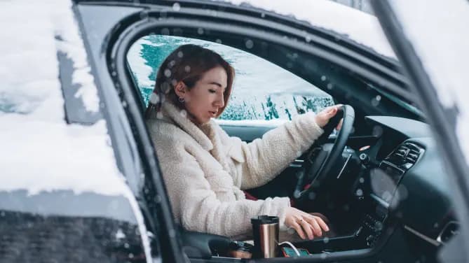 women starting her car in a snowstorm