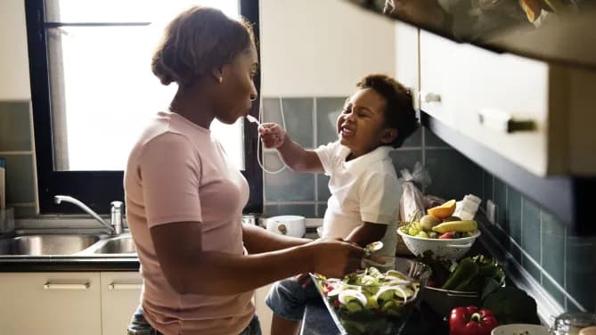 Woman eating salad with child