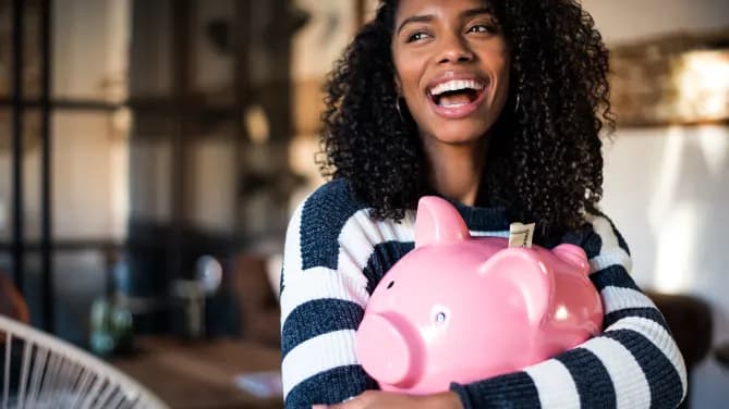 woman holding a piggy bank and smiling