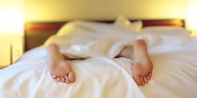 Feet hanging off of bed