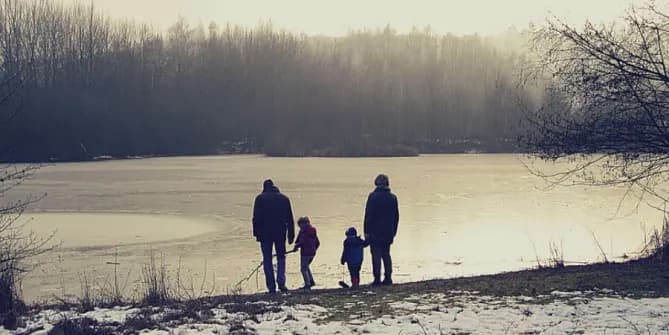 Grandparents and grandchildren by a lake in winter